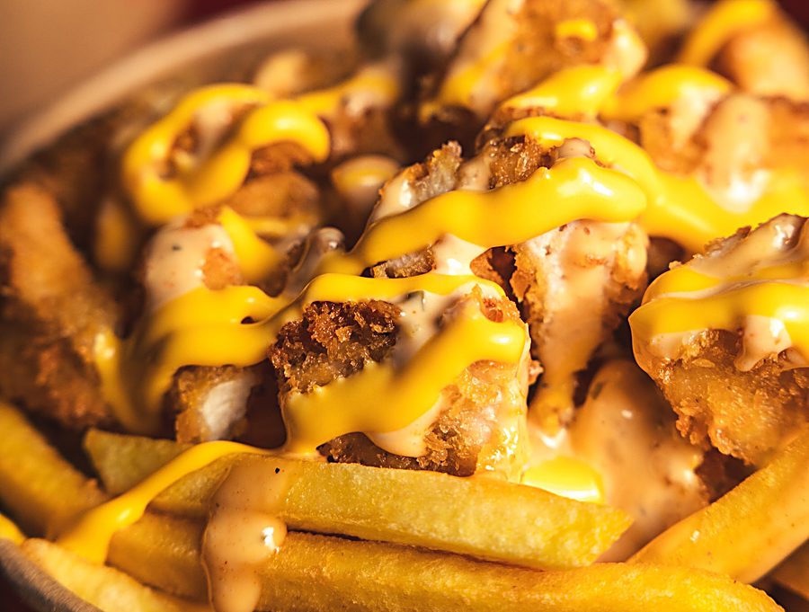 Papas con pollo crispy y salsa de queso cheddar