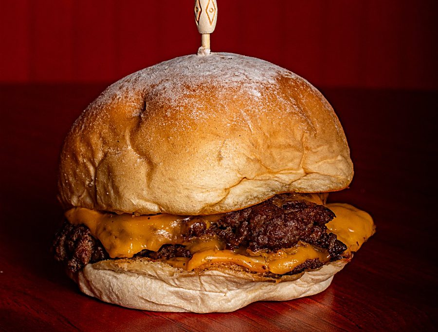 Hamburguesa smash con papas a la francesa servida en la caja de Muncher